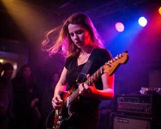 Gitarristin im farbigen Bühnenlicht bei einem Konzert in einem Schaffhauser Club